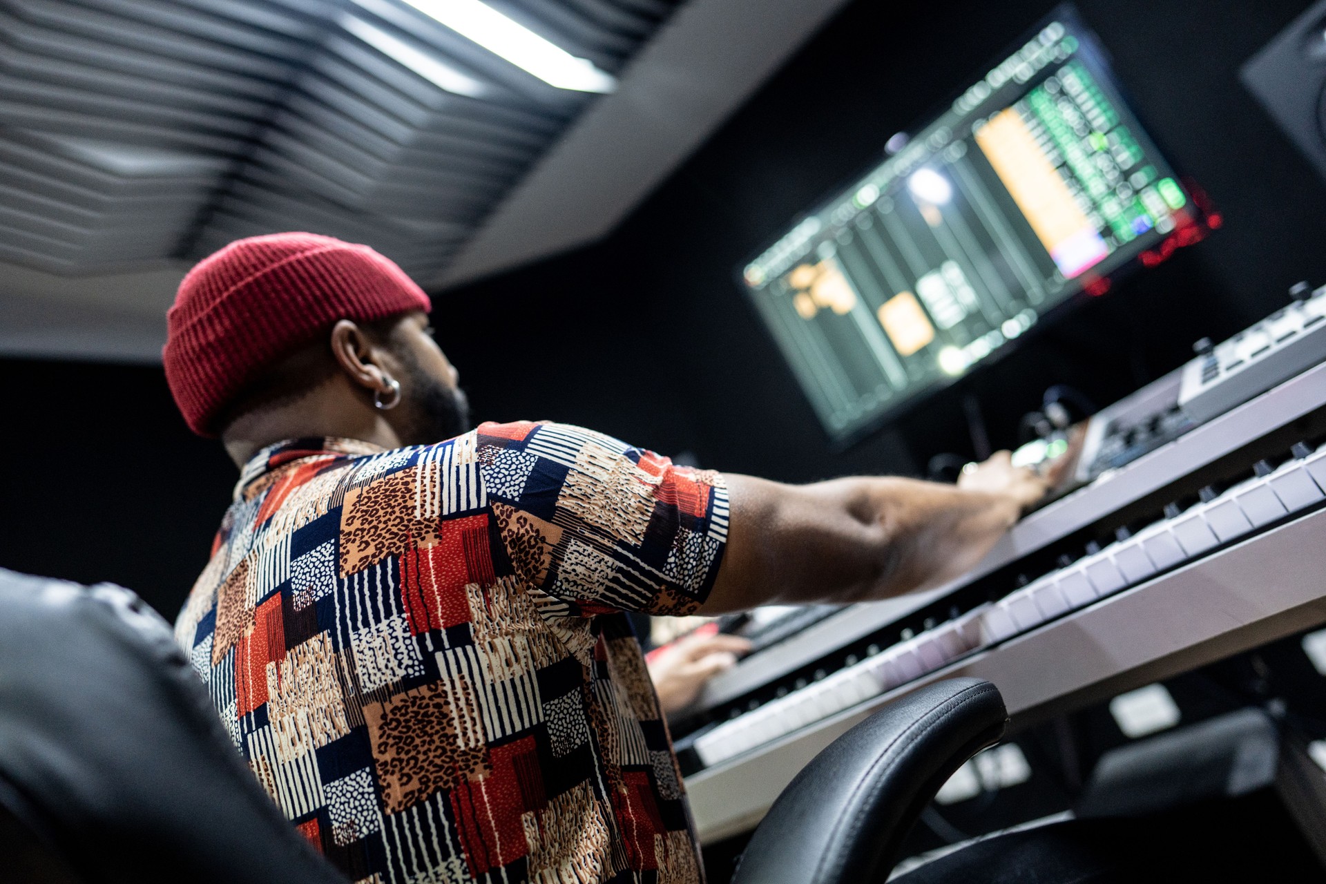 Rear view of a producer man using a sound mixer in the recording studio